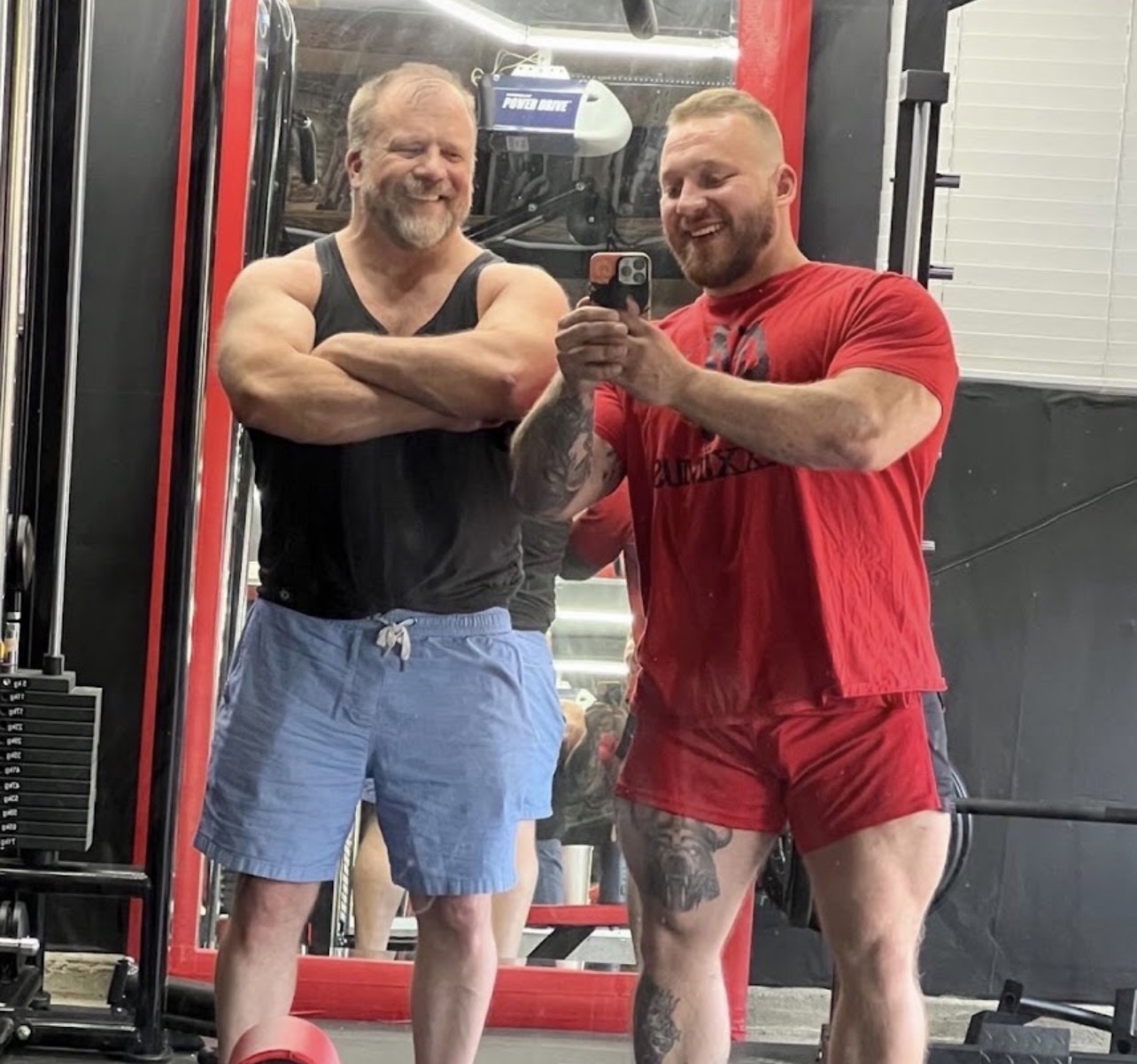 Dean Fogarty and Colton Britzius laughing together between sets in the gym